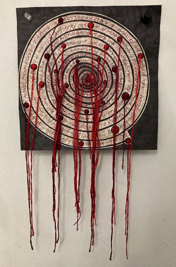 image of a textile work, concentric circles with dripping red punctures