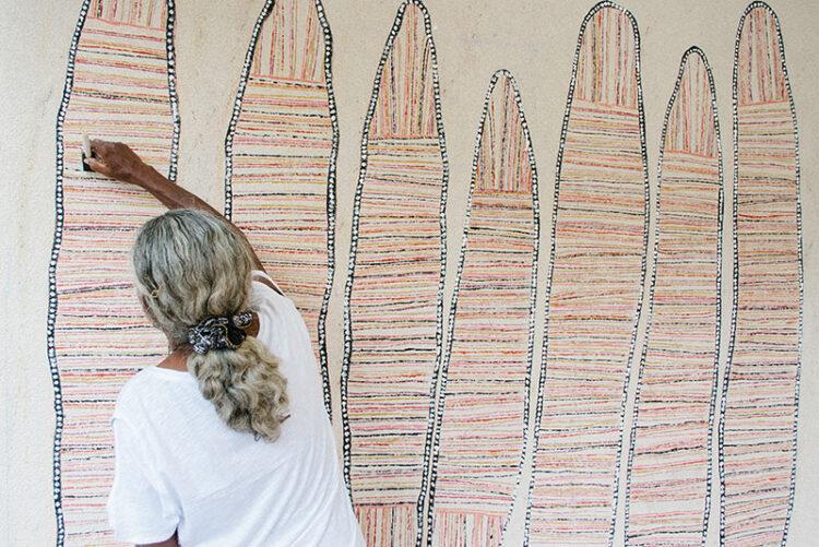 Regina Pilawuk Wilson works on her mural