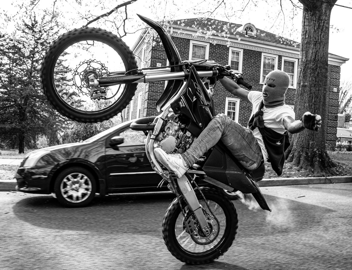 Black and white photograph of a man on a dirt bike