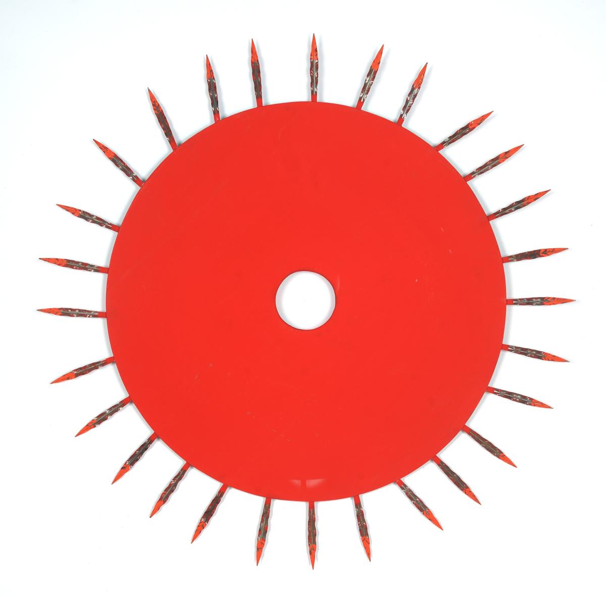 A sculpture of a flat red circle with red spikes coming out of it on all sides