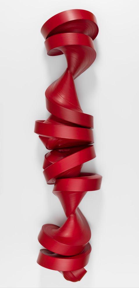 A sculpture made with a large roll of red paper