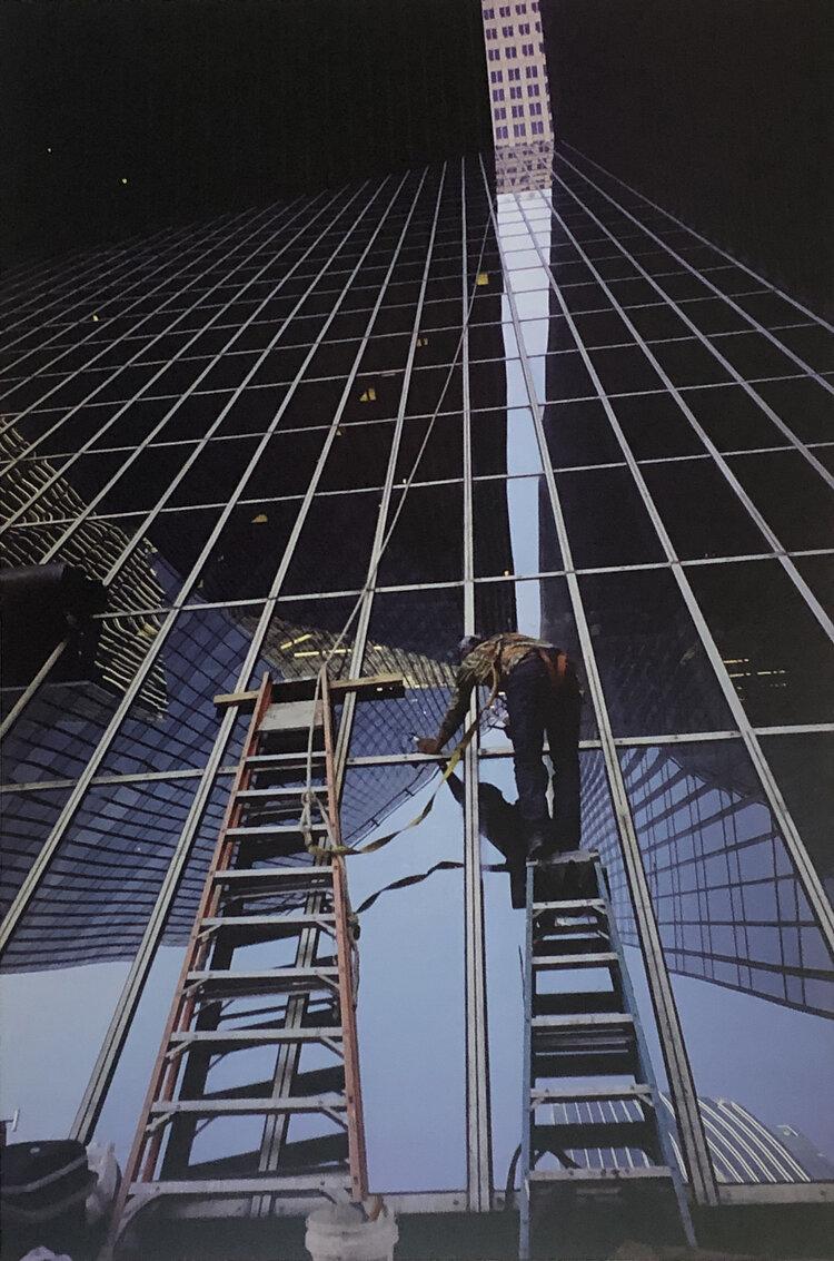 Photograph of a person cleaning a skyscraper