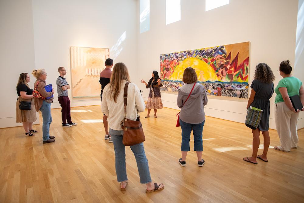 Educators observing a large painting, led by a Phillips educator