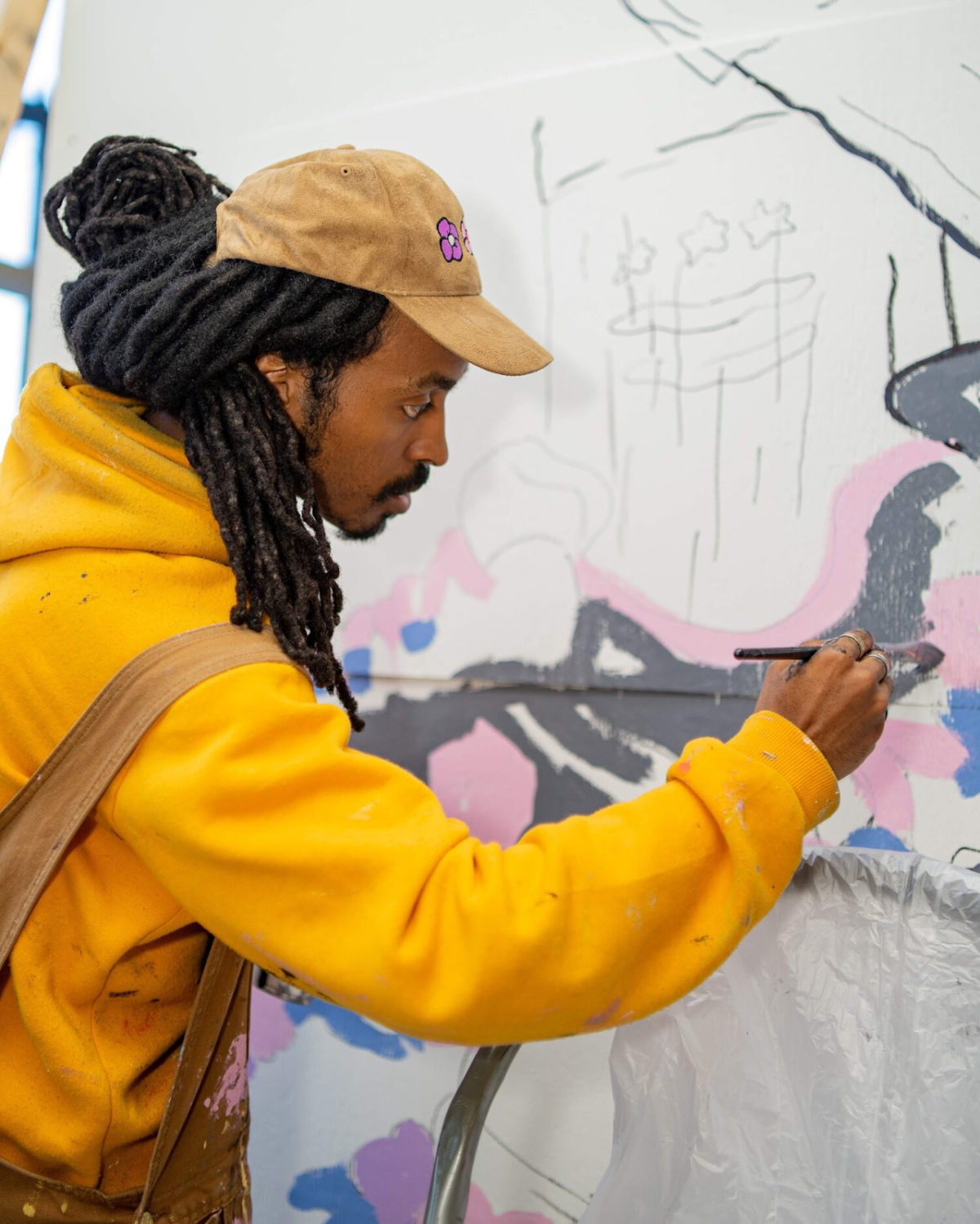 Photograph of Chris Pyrate painting a mural