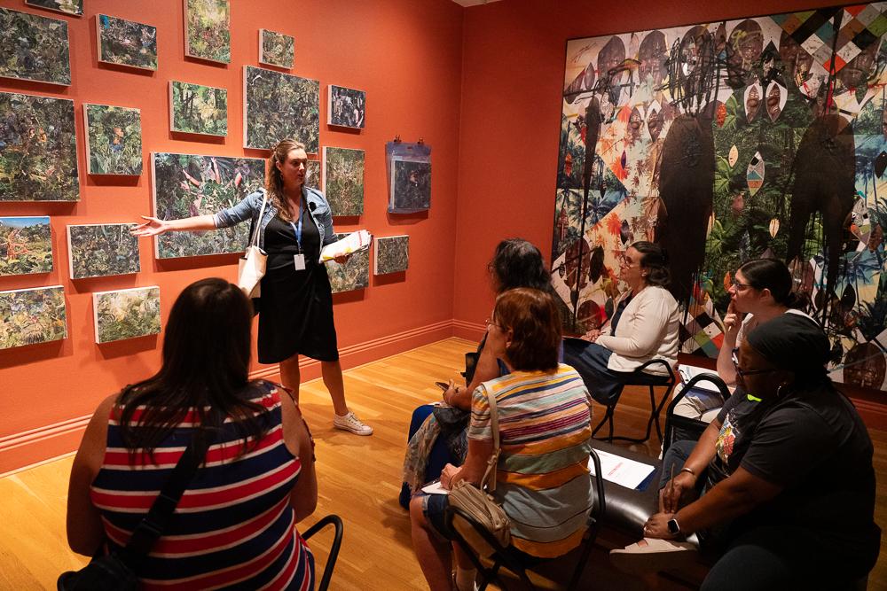 Photograph of someone giving a talk about an artwork in a gallery