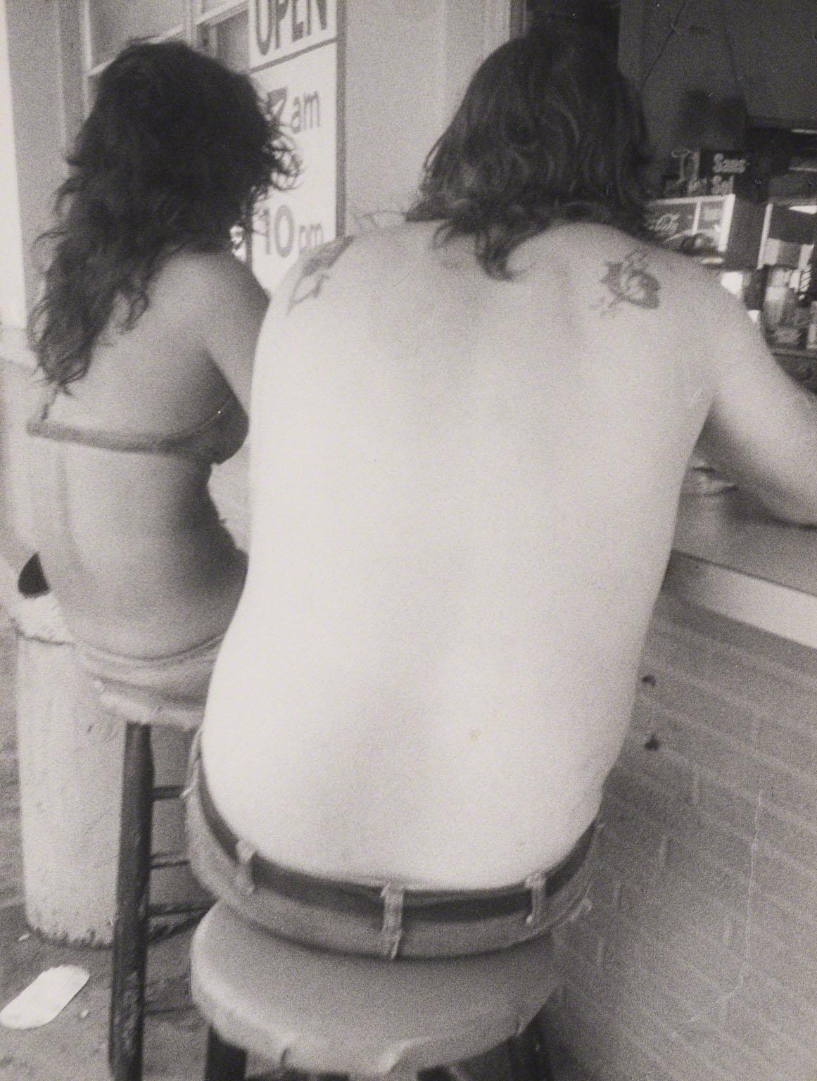 Leon Levinstein, Coney Island (couple sitting on stools, on boardwalk), c. 1970.