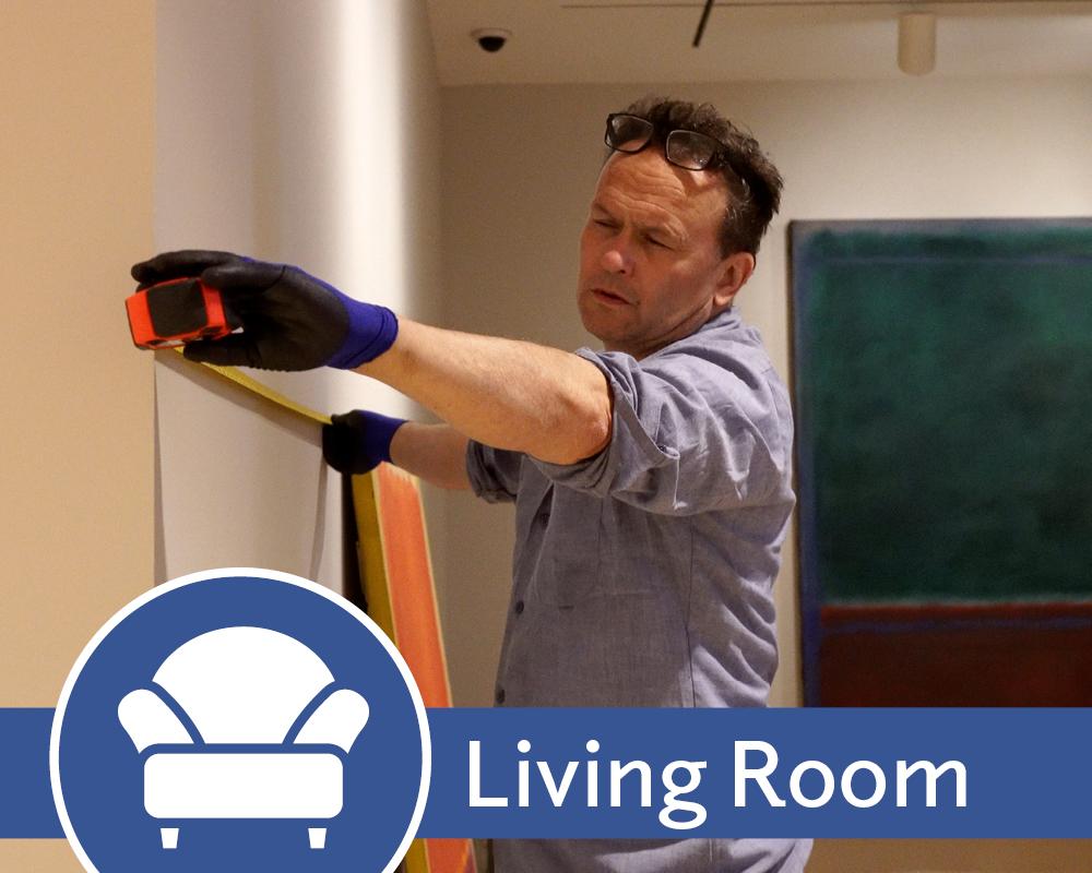 Living Room promo image with Alec measuring a wall