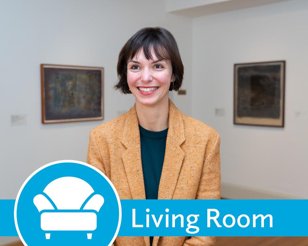 Photo of Clarisse Fava-Piz wearing a blazer standing in a gallery with art on the walls