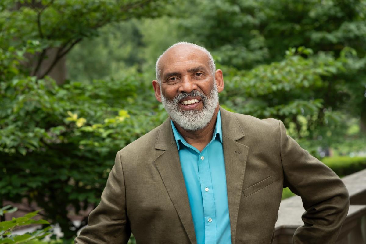 Headshot of Richard Powell in a suit with trees in the background