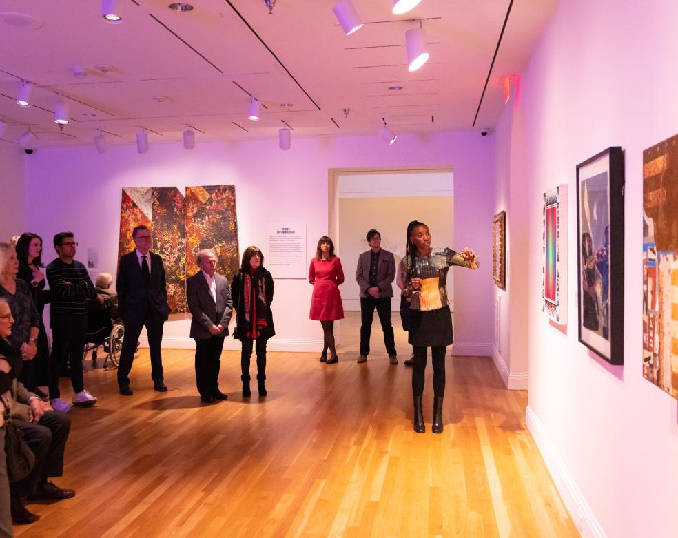 Photograph of a woman giving a talk in a gallery