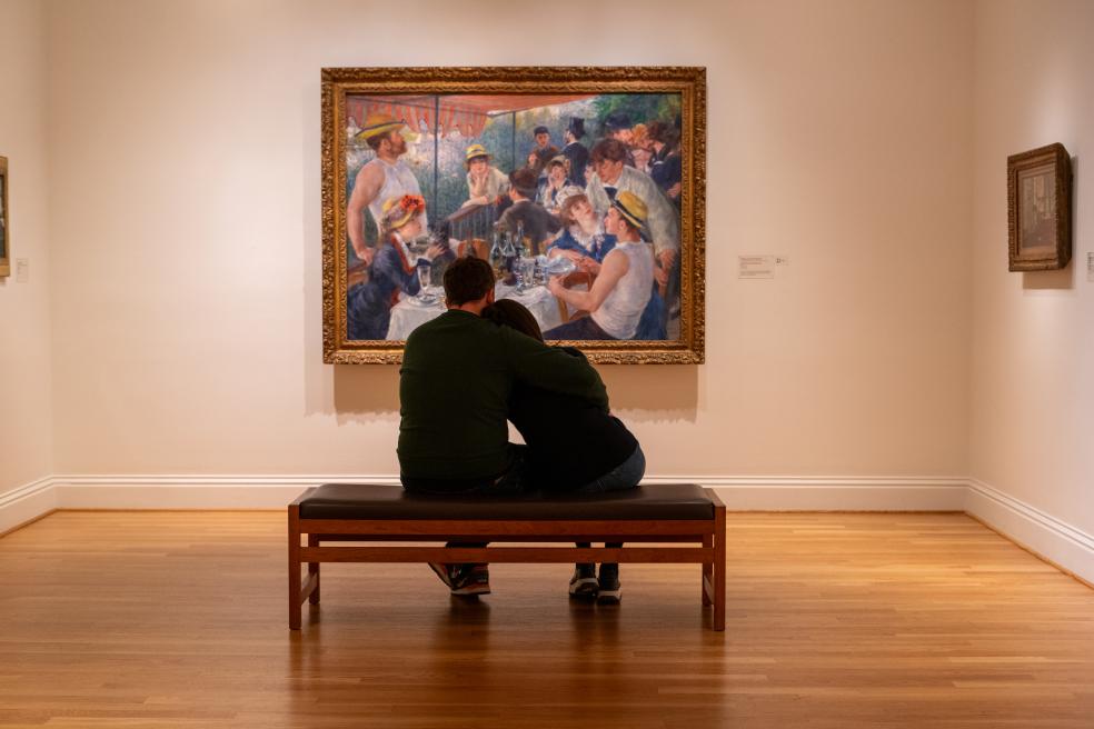 Two people sitting and looking at Luncheon of the Boating Party