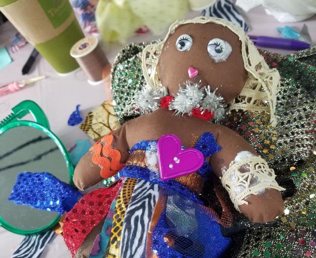 Photo of a hand-made Black baby doll with colorful embellishments