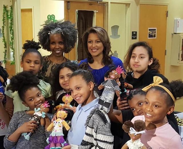 Photo of group of African American girls smiling and holding black dolls