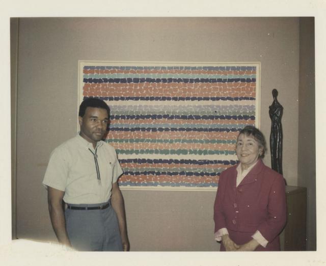 Photograph of David Driskell and Alma Thomas standing in front of a painting by Thomas