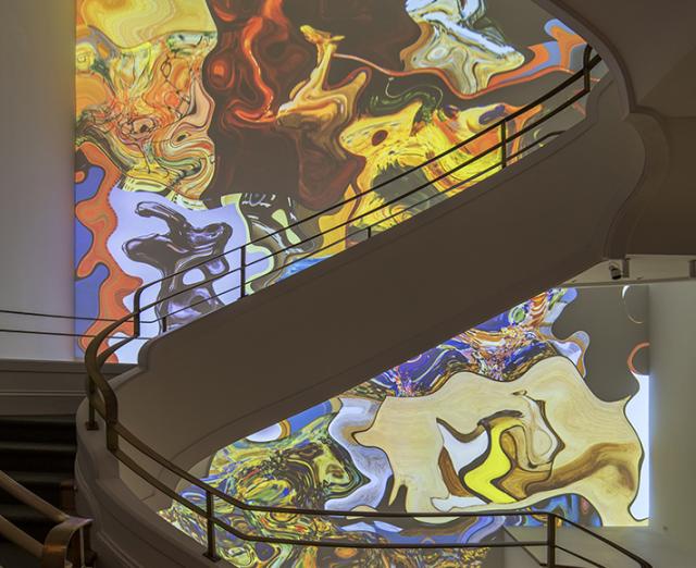 Curved white stairwell with colorful swirling colors on the back wall