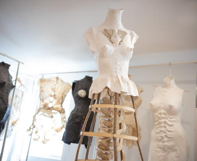 A group of black and white torsos made of paper 