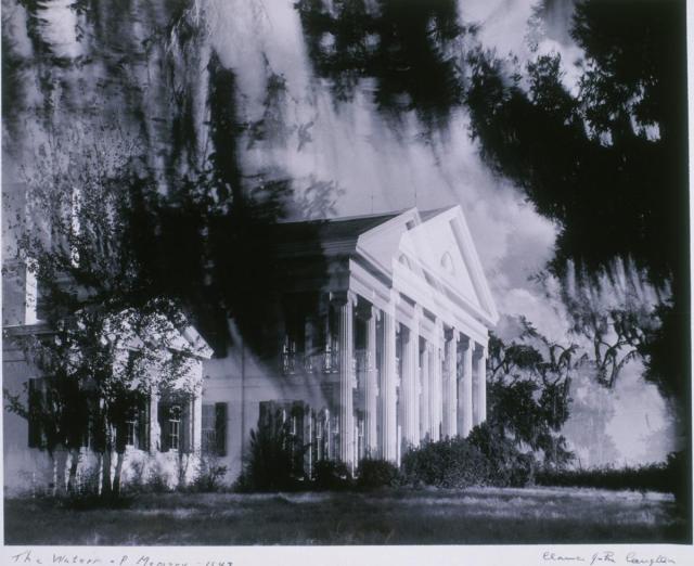a black and white photograph that seems to be double exposed, of a stately white house