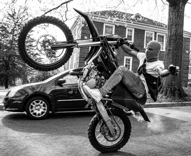 Black and white photograph of a man on a dirt bike
