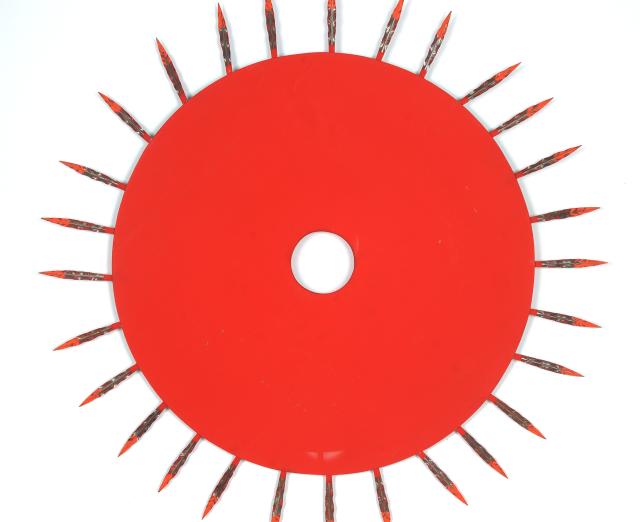 A sculpture of a flat red circle with red spikes coming out of it on all sides