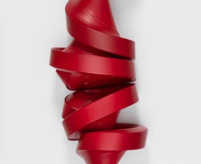 A sculpture made with a large roll of red paper