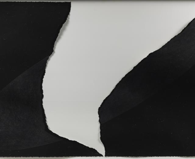 Black paper with large white tear in middle