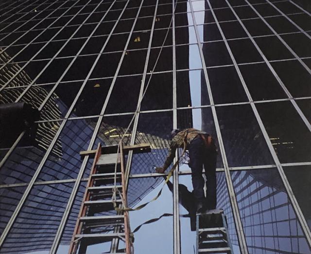 Photograph of a person cleaning a skyscraper