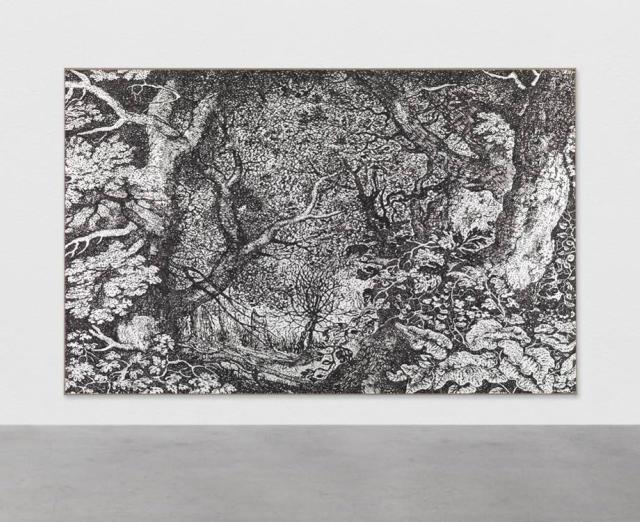 Photograph of large black-and-white artwork of forest hanging on gallery wall