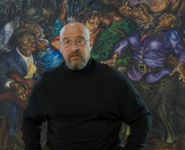 Rik Freeman standing in front of one of his paintings