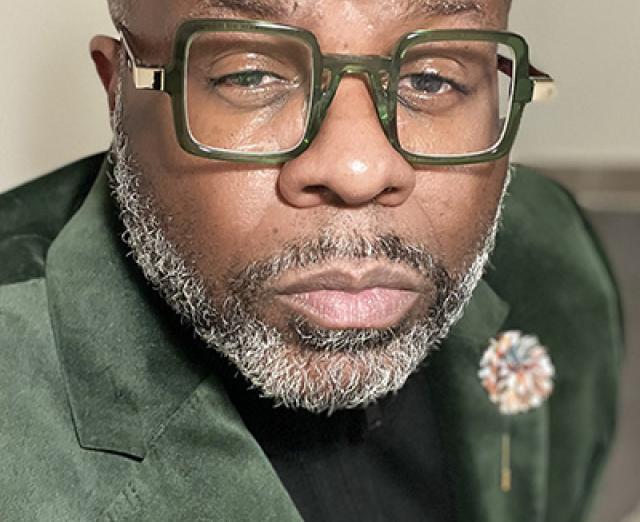 Photograph of Eric Flemming leaning into the camera with eyes squinted