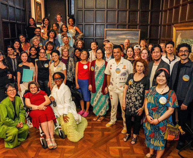 Group of around 40 people standing together in the Phillips Music Room