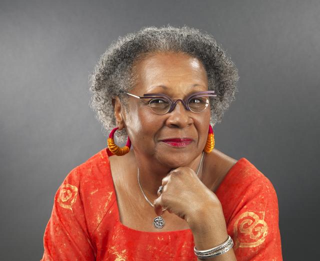 Photo of Imani Gonzalez wearing a red, leaning on table