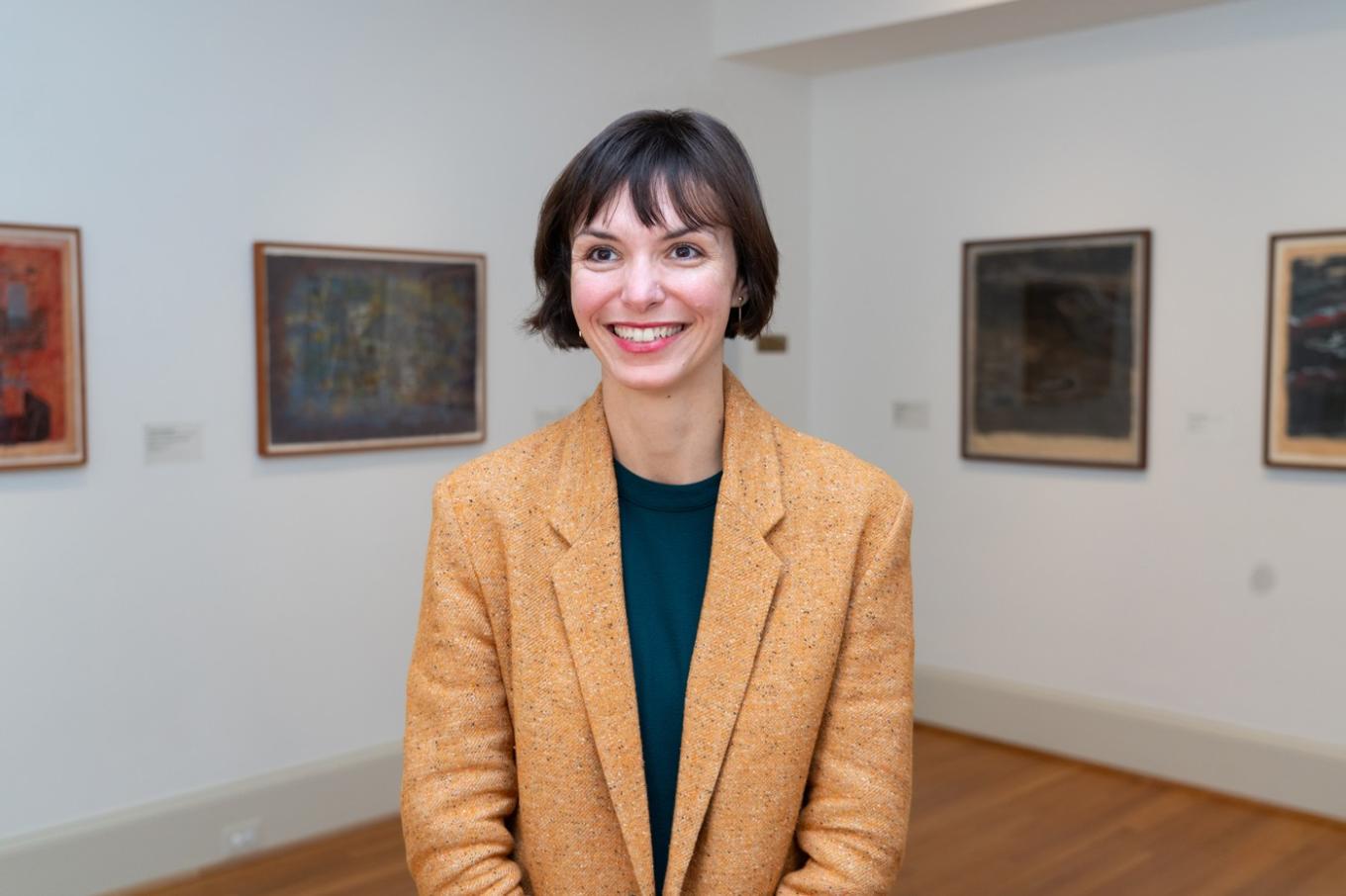 Clarisse Fava-Piz headshot in a gallery with art on the walls