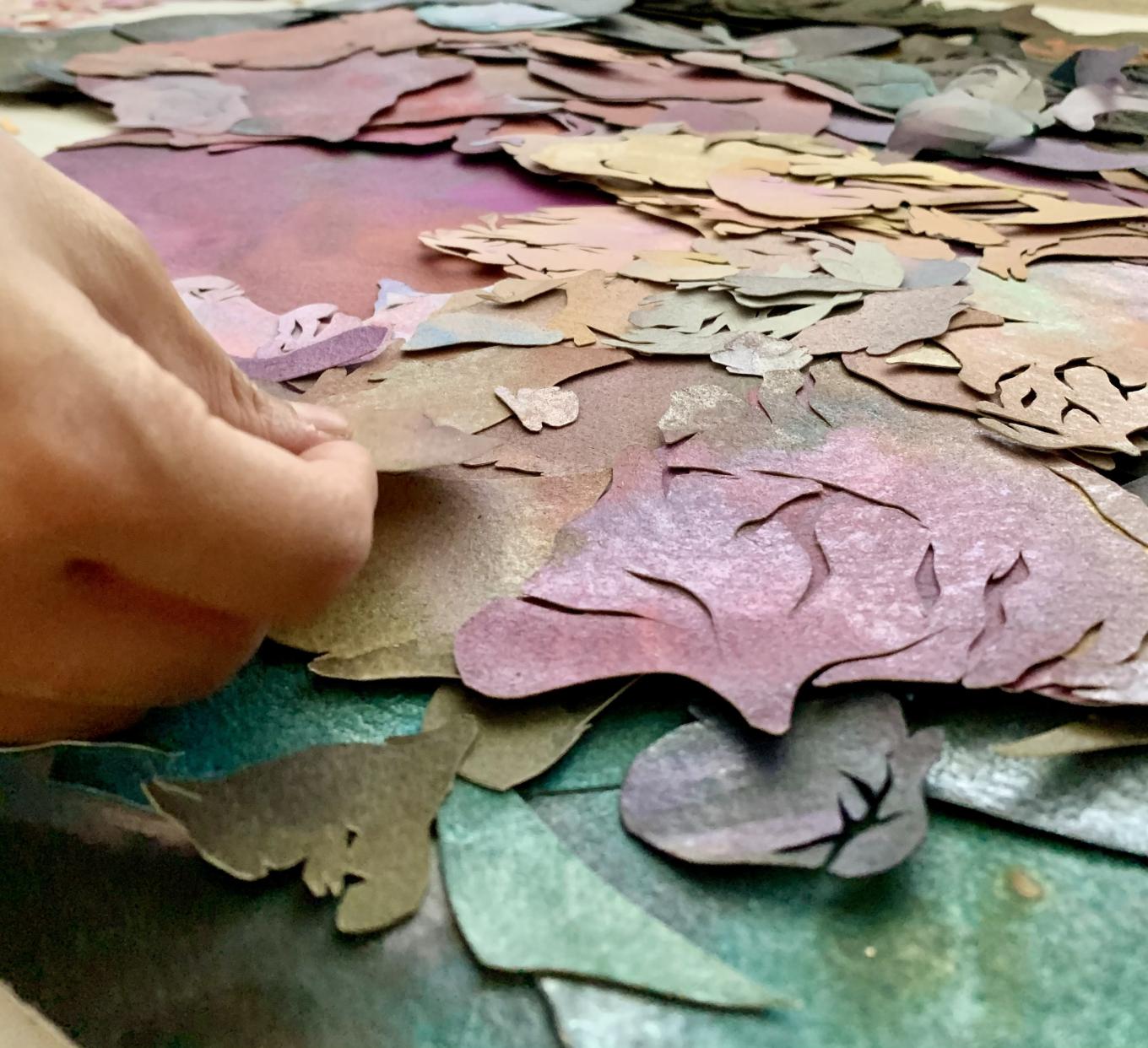 Artist hand placing hand-painted paper