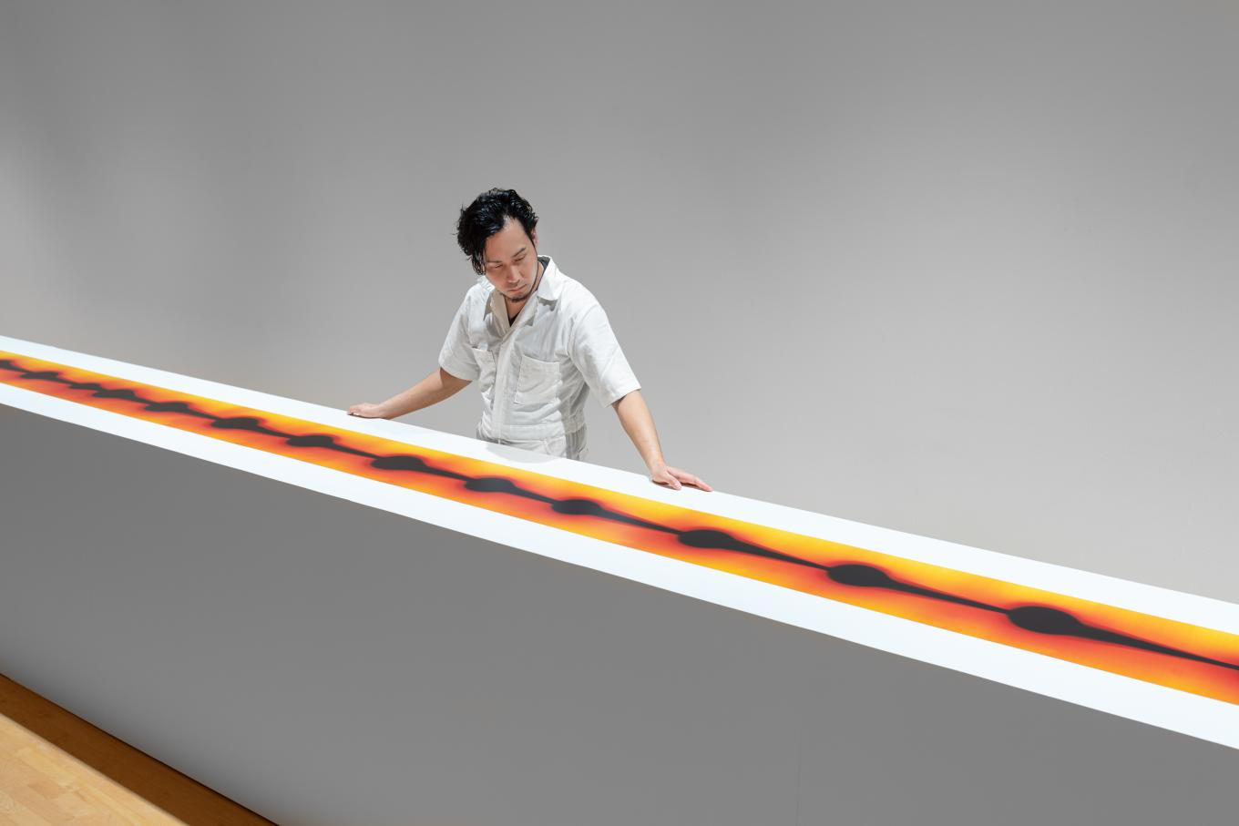 Kei Ito looking at his scroll artwork