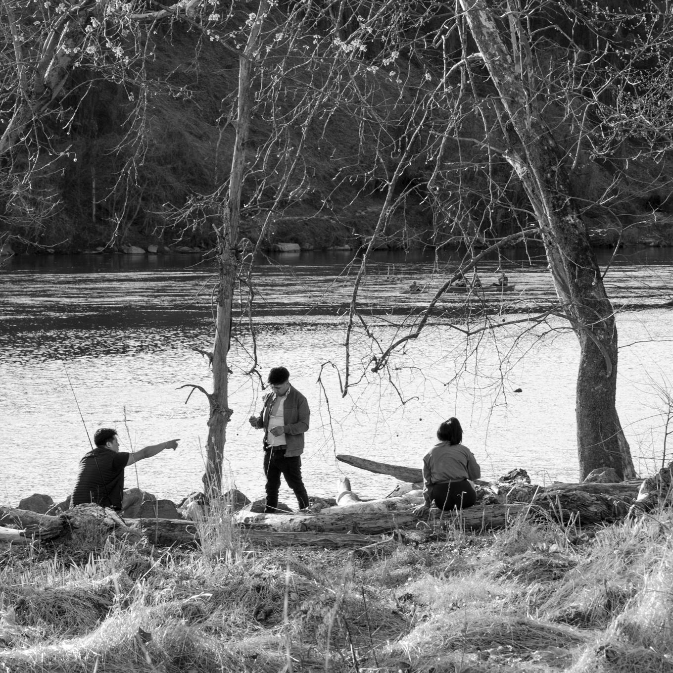 Black and white photograph of people by a river