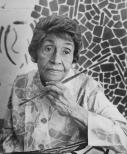 Black and white photograph portrait of Black artist Alma Thomas holding a paint brush with a painting in the background
