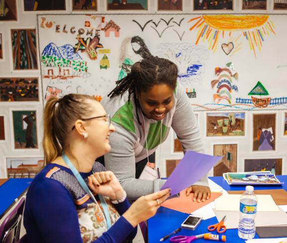 Photograph of two women smiling in a room with art supplies