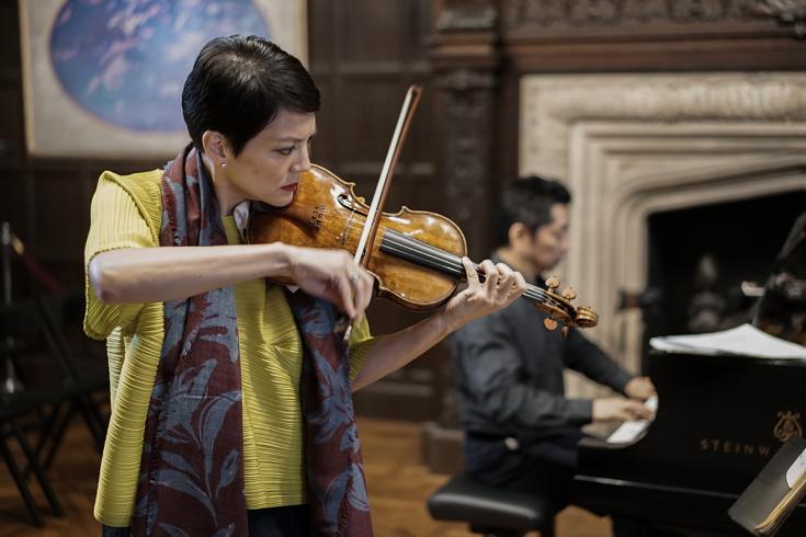 Violinist Anne Akiko Meyers performing in the Music Room, with a pianist in the background