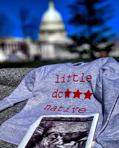 Photo of sonogram on a baby shirt with the Capitol in the distance