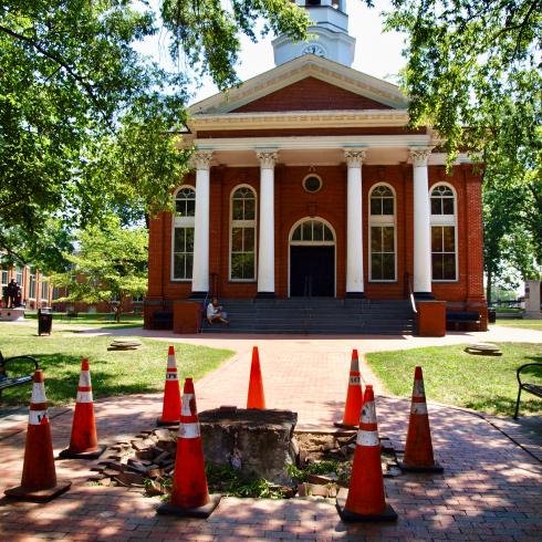 Photo of a building with a statue that has been removed with cones around where it used ot be