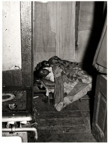 Old black and white photography of children sleeping in small home
