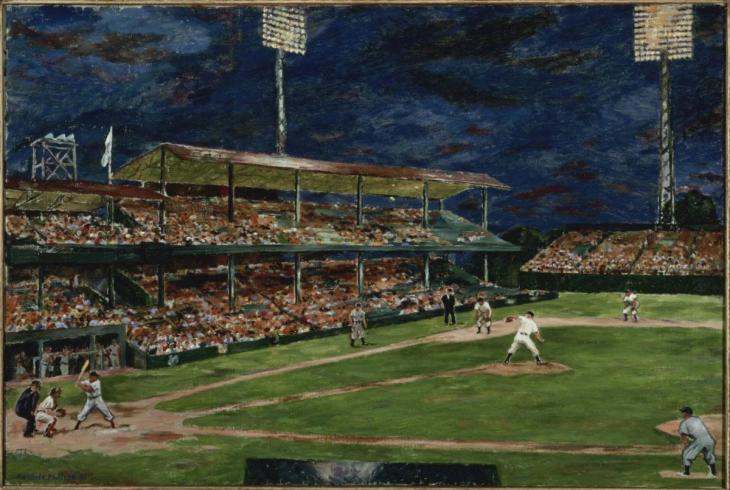 A baseball game playing in a stadium at night.