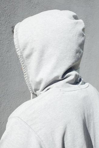 black and white photograph of back of head wearing hoodie