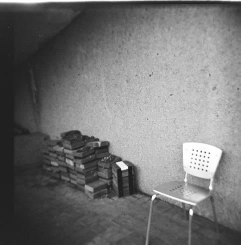 Black and white image of an empty metal chair 