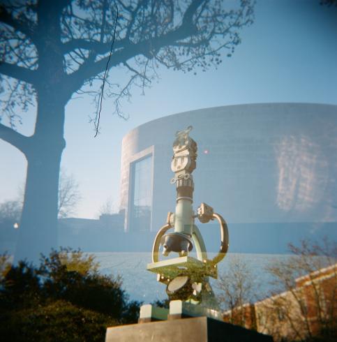 A double exposed image of a building and statue 