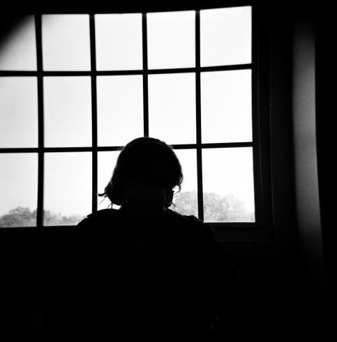 Black and white image of a person's silhouette against a window  