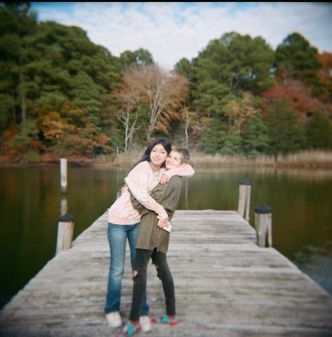 Image of two people embracing each other and smiling on a lake 