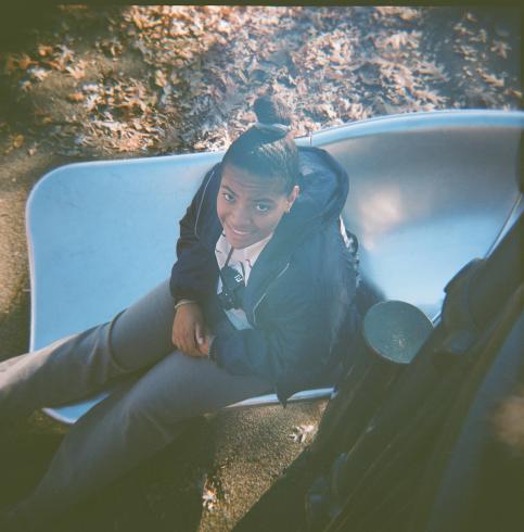 Image of a person on a slide looking up at the camera smiling 