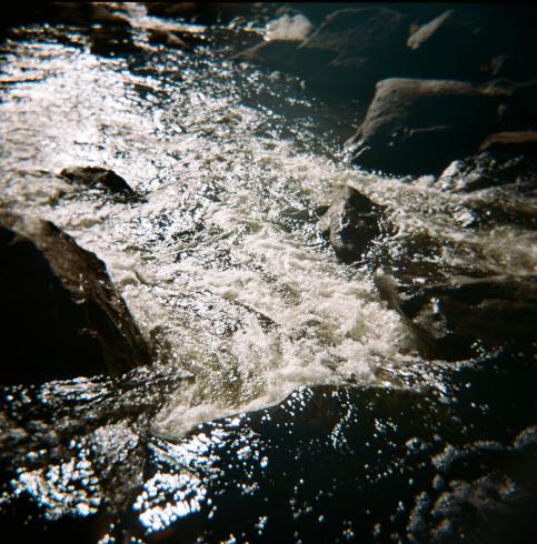 Image of water flowing by rocks 