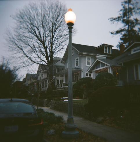 Image of a green house in a neighborhood 